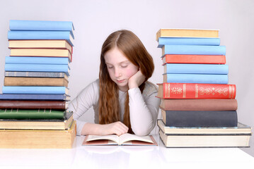 Portrait of a red-haired freckled girl with a lot of books.