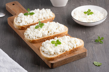 Bread with curd cheese on wooden board