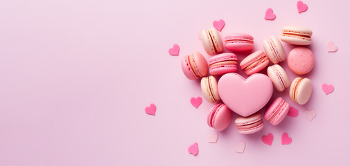 Obraz na płótnie Canvas Sweet macaroons in heart shape on pink background. French cookies with vanilla, raspberry and strawberry. Pastry shop banner with copy space