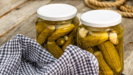 Glass jars with pickled red bell peppers and pickled cucumbers (pickles) isolated. Jars with...