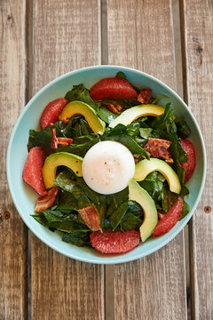 Spinach salad with grapefruit, avocado, bacon and poaceh egg.