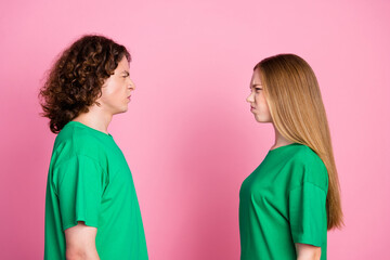 Side profile photo of two funny aggressive youth couple looking each other with strict when arguing...