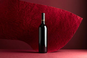 Bottle of red wine on a red background.