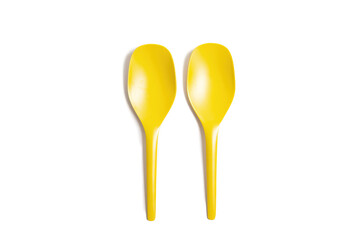 two yellow plastic spoons isolated on white