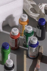 Several bottles of colored acrylic paint on a table in an artist's creative studio. Multicolored paint. Creative mess. Material for drawing pictures. Art studio. Painting gallery.