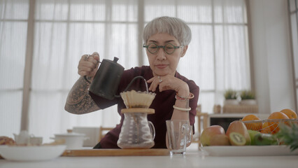 Asian mature women brewing coffee in home
