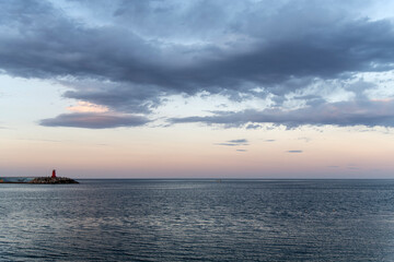 Seascape with big white clouds on the horizon in the late afternoon
