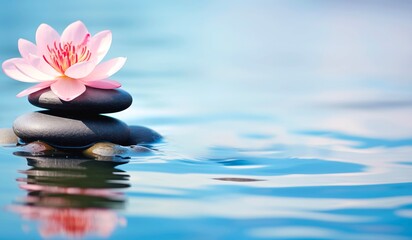 The serene and calming atmosphere of zen stones and a water lily in clear water. Ideal for wellness or spa concepts with space for copy text.