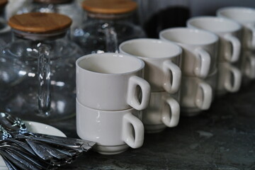 White porcelain cups are lined up in a row on the table.