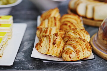 Fresh appetizing croissants on a white plate.
