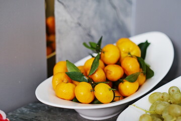 Tangerines on a white plate.