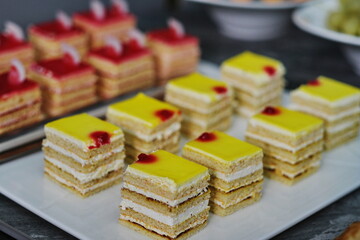 Tempting pastries with yellow cream on a white plate, close-up.
