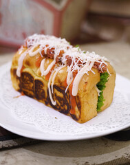 Fresh grilled delicious sandwich with topping and filling plated in white plate, just freshly baked