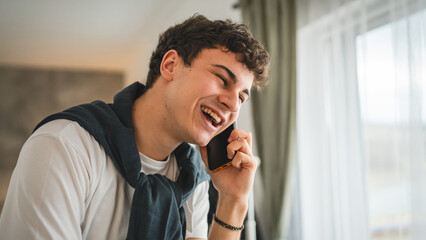 One teenage man stand at home have a call use mobile phone smartphone