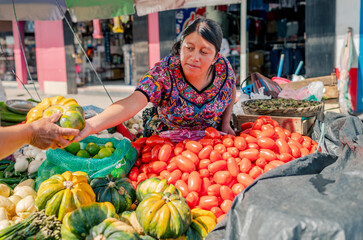 Latina saleswoman delivers a pumpkin to her customer.