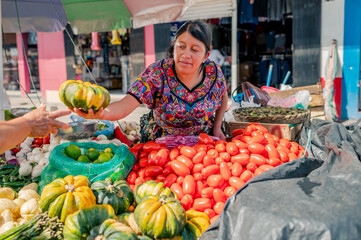 Indigenous seller at a vegetable stand in a market in Guatemala.