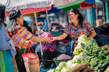 Happy vendor at a market in Quetzaltenango serves her customer.