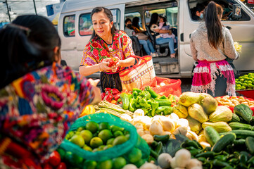 Latina shopper chooses the vegetables she will buy.