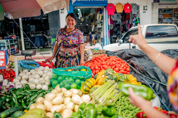 Latina vendor from a cantonal market talks to a buyer.