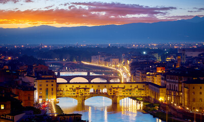 Florence, Tuscany, Italy. Evening sunset over Firenze with Ponte Vecchio bridge on Arno river and tower in italy. Scenic panoramic top view at the ancient city. Famous travel destination landmark.
