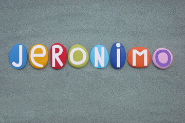 Jeronimo, masculine given name composed with hand painted multi colored stone letters over green sand