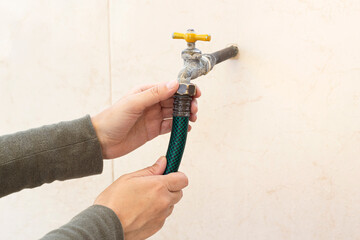 Connecting garden hose to the spigot. Attaching hose to outdoor faucet