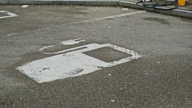 Electric Car Designated Parking Spot by Plug In Charger for Fast Charging Battery at Outdoor Parking Lot