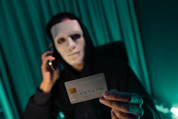 White criminal anonymous mask calling to credit card owner to threaten ransom with privacy...