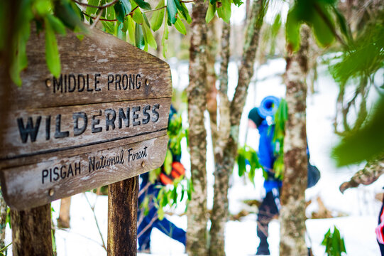 Backpackers pass a National Forest wilderness sign in winter.