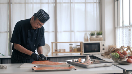 Japanese chef cooking salmon in kitchen