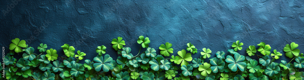 Poster border made of clover leaves on dark blue background with copy space. four leaved shamrocks. st patr