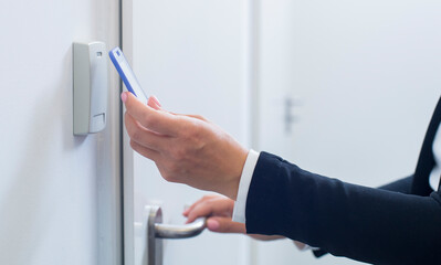 hand opens the door with a magnetic key in the office