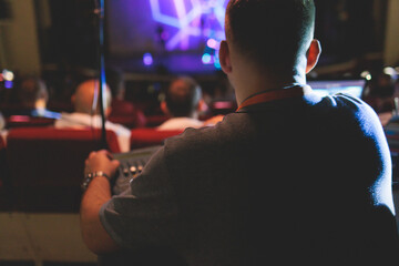View of lighting technician operator working on mixing console workplace during live event concert...