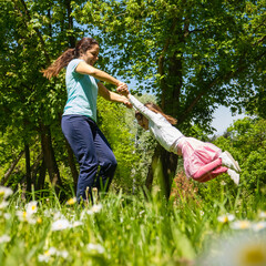 Mother spinning her daughter