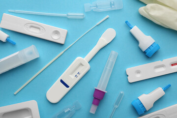 Disposable express test kits on light blue background, flat lay