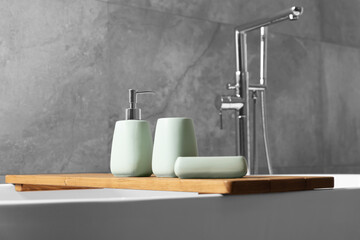Set of bath accessories on tub in bathroom