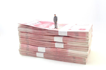 a business man stand on Stacks of Chinese Yuan Banknotes,