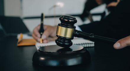 Judge gavel with Justice lawyers having team meeting at law firm background. Concepts of Law and...