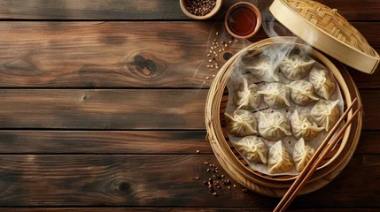 Schilderijen op glas Top view fresh dumplings with hot steams on wood plate with chopsticks. Chinese food on rustic old vintage wooden background. © buraratn