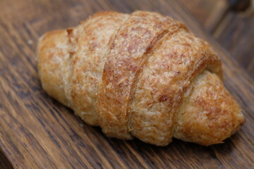 whole wheat croissants on wooden cutting board. croissant, which originated in France, is so named because of its shape resembling a crescent moon. made from wheat, eggs, salt, margarine.