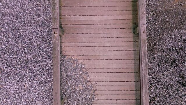 Aerial top view video of a wooden pier over the beach