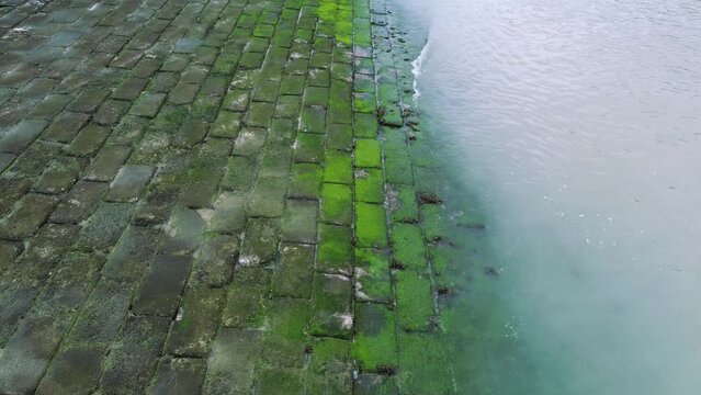 Sea waves crashing on stone bricks on the shore