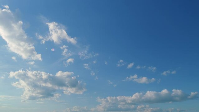 Floating Fluffy Clouds. Two Layers Of Cloudiness. Blue Summer Sky With Clouds Moving In Different Directions.