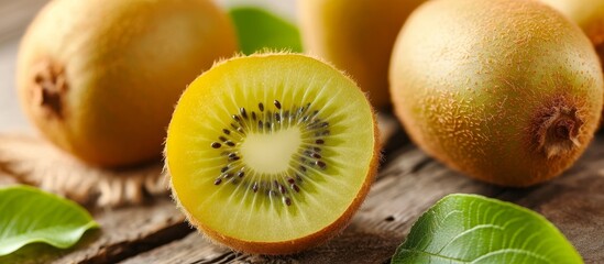 A close-up of a halved kiwi, a Hardy kiwi fruit, on a wooden table showcasing its natural beauty as a staple food.