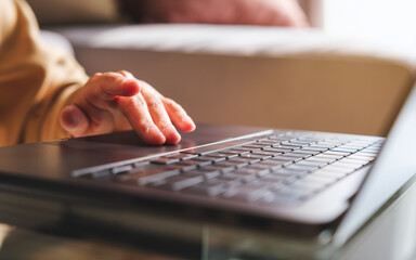Closeup image of a hand working and touching on laptop computer touchpad at home