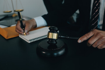 Judge gavel with Justice lawyers having team meeting at law firm background. Concepts of Law and Legal services.