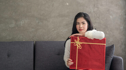 woman sit on sofa hold big red gift in hand, happy and smile for gift tell love special day, Valentine's day.