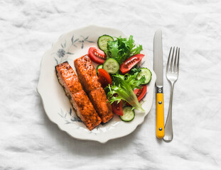 Healthy diet lunch - teriyaki sauce baked salmon and fresh vegetable salad on a light background, top view