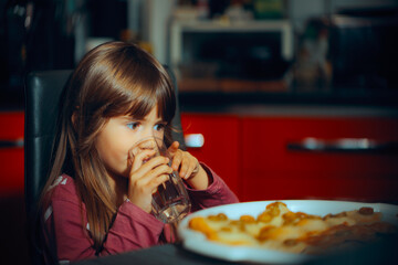 Toddler Girl Having a Glass of Water During Lunch Time. Thirsty kid hydration during eating her lunch meal 
 - obrazy, fototapety, plakaty
