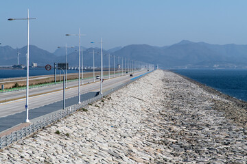 Seascape with the road constructed on the seawall on a sunny day